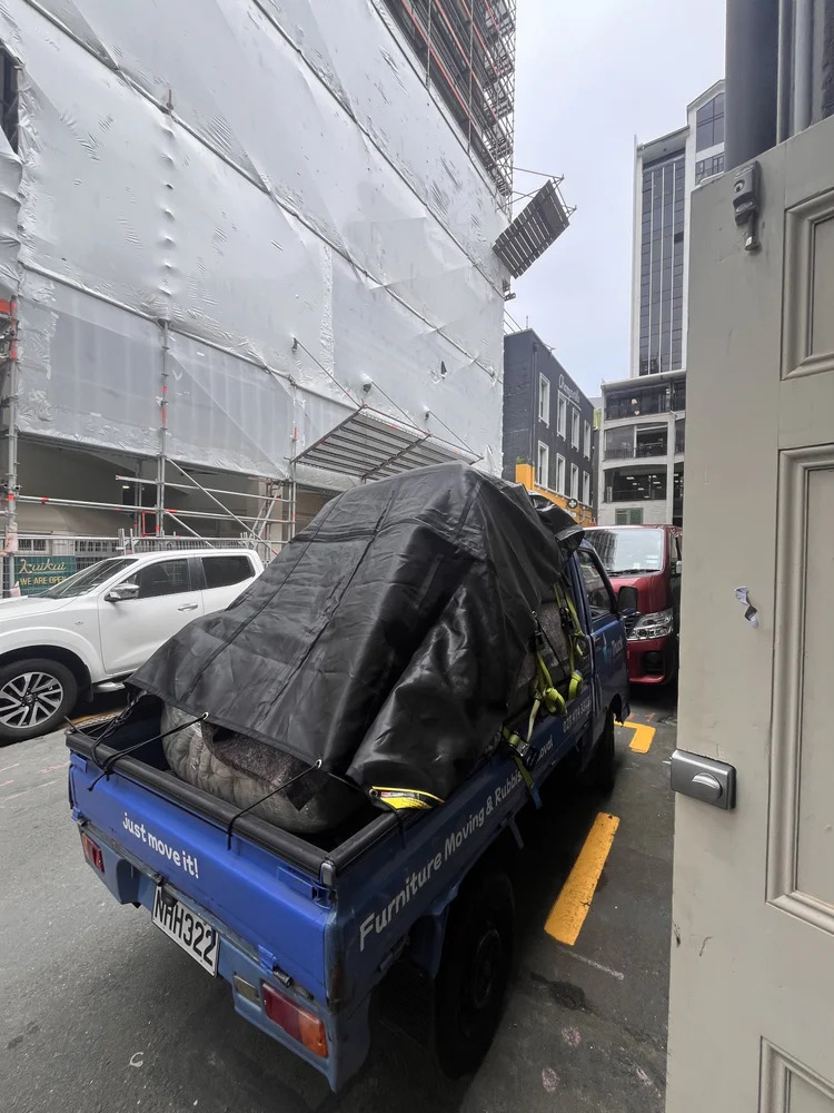 The Tiny Truck loaded high with a tarped clear-out load on a Wellington city street