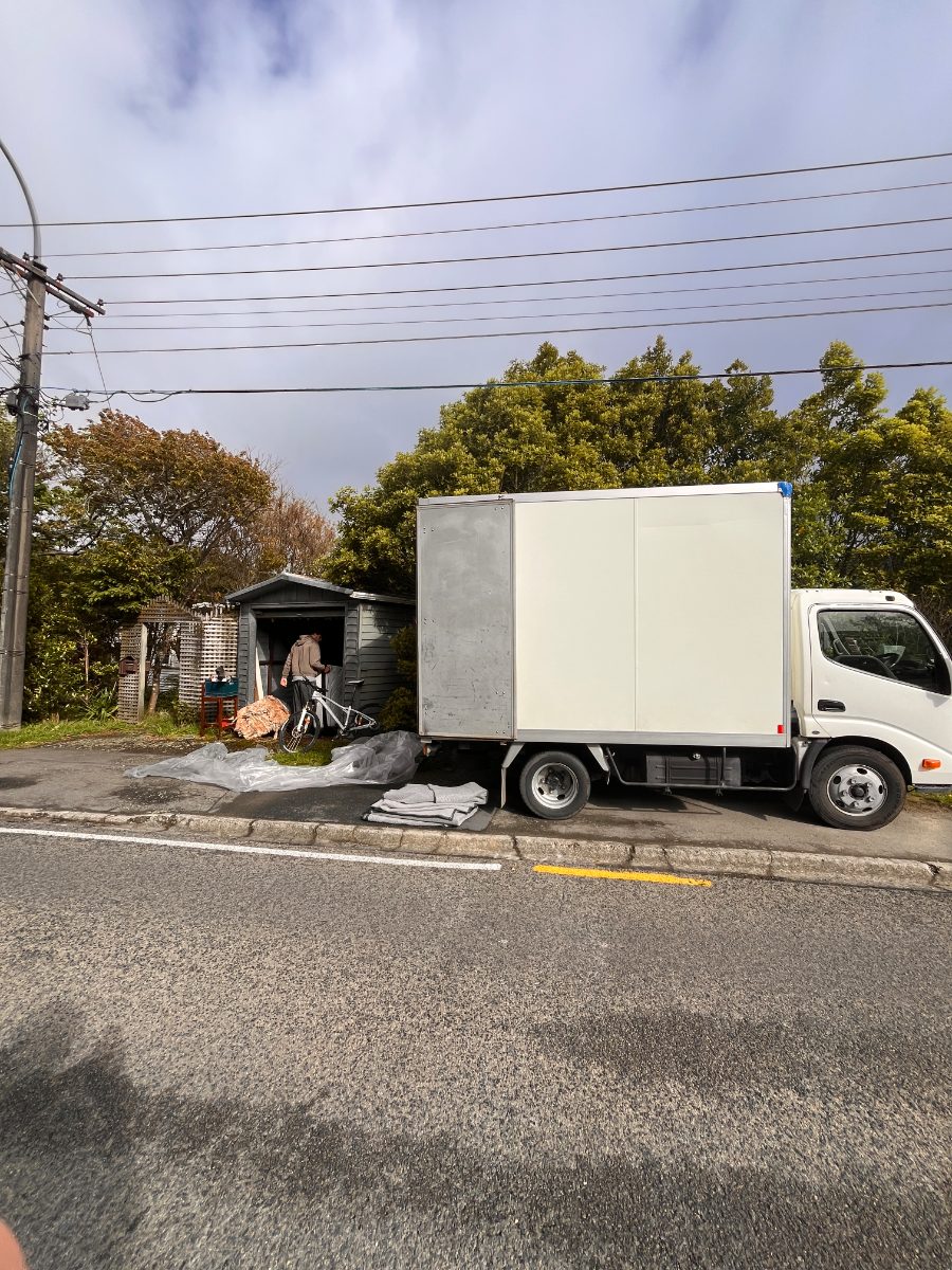 The truck parked kerbside with blankets and covers laid out, ready to clear an old backyard shed